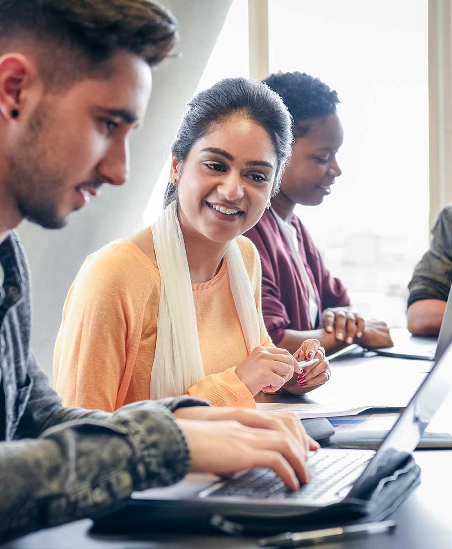 Classmates looking over classwork on a laptop